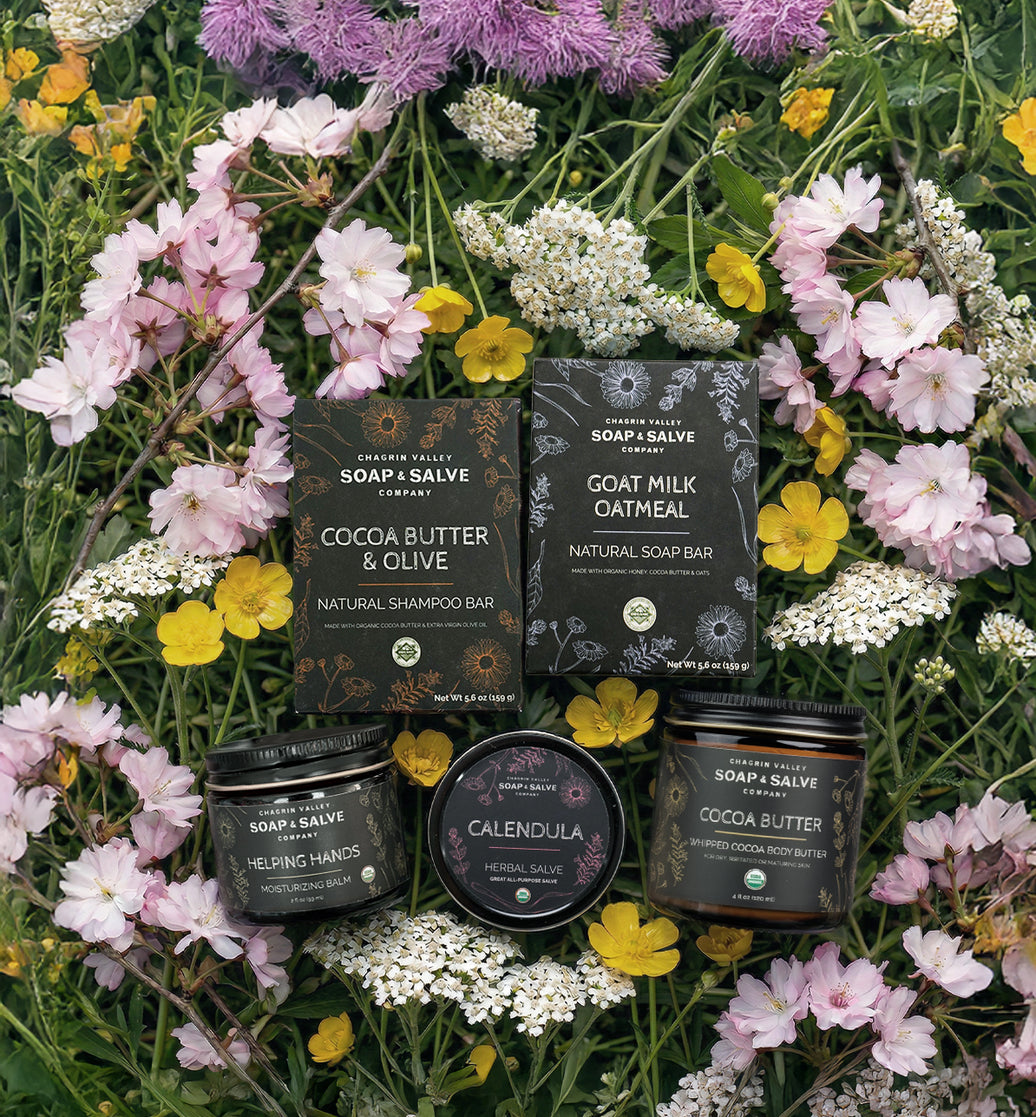 Cosmetic products from Soap & Salve Company on a bed of flowers