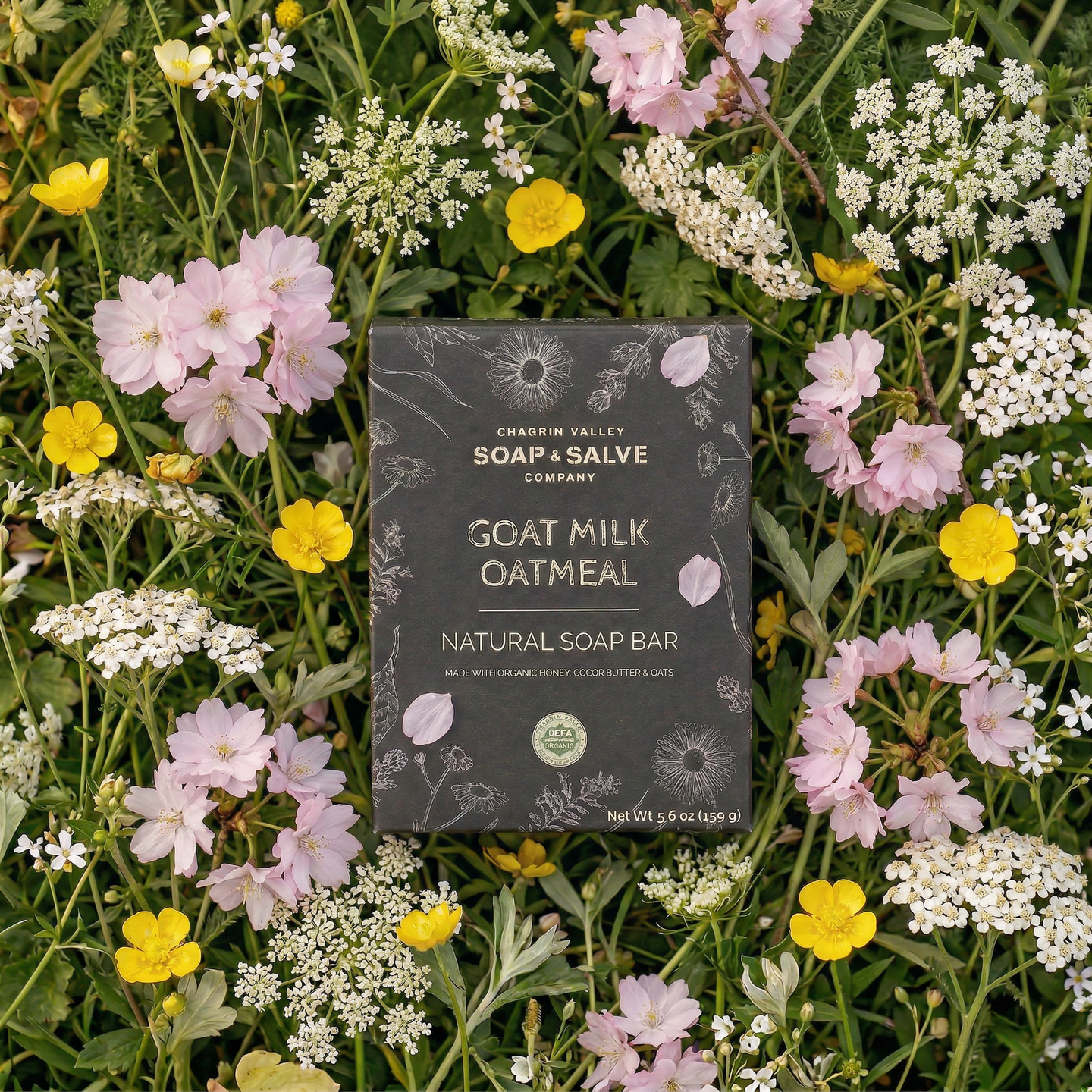 Goat Milk Oatmeal natural soap bar from Orchard Valley Soap & Salve Company surrounded by wildflowers.